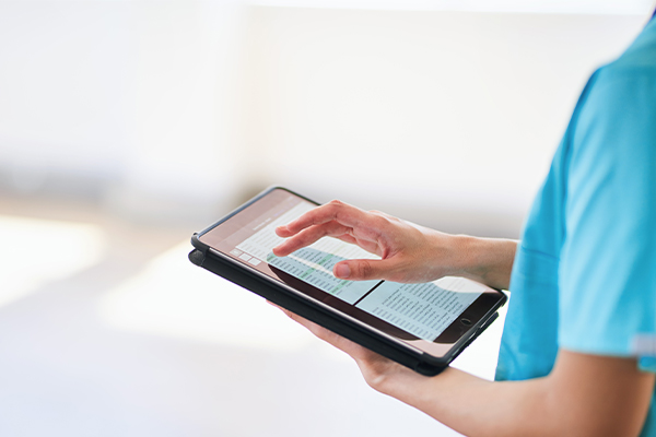Medizinische Fachkraft nutzt Tablet für digitale Patientenakten