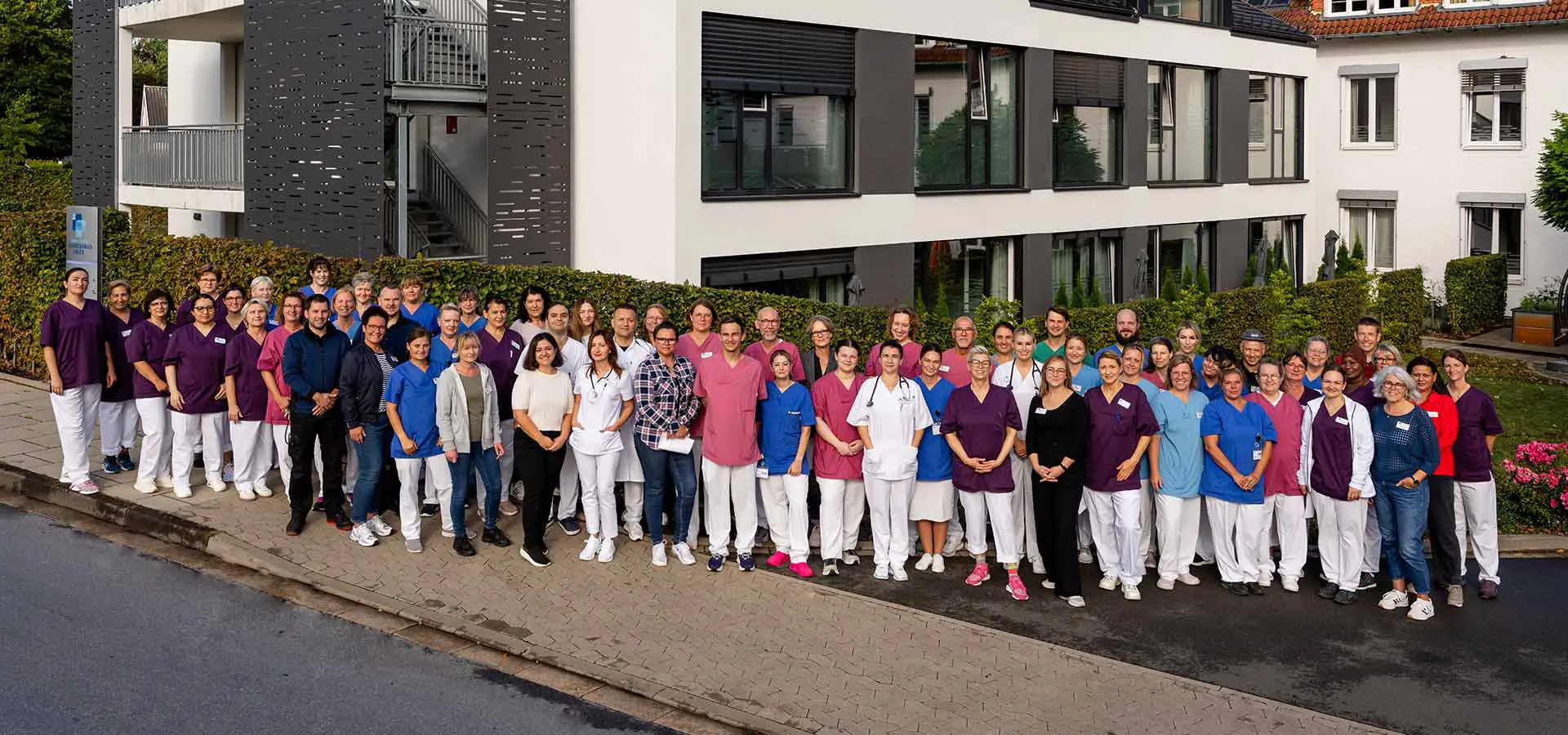 Team der Geriatrischen Fachklinik Enger, Außenaufnahme aller Mitarbeiter vor dem Krankenhausgebäude