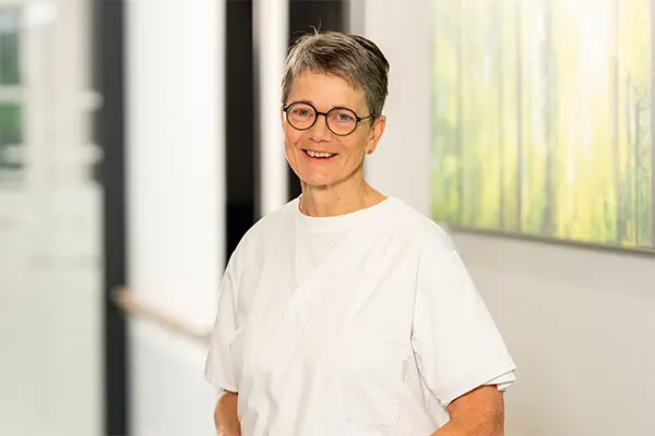 Porträt von der Oberärztin in weißem T-Shirt vor unscharfem Hintergrund