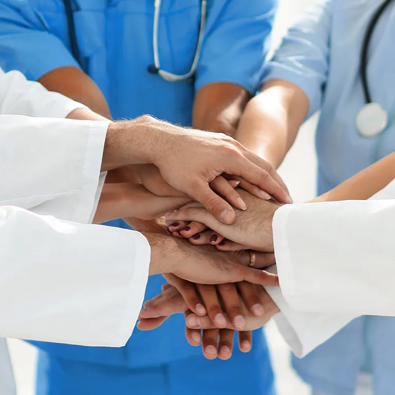 Karriere Symbolbild, Ärzte und Krankenschwestern reichen sich die Hände, Symbol für gegenseitige Hilfe